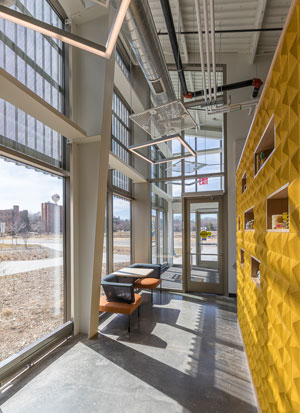 Perforated metal panels in front of the glass in the research lab’s lobby provide sunshade, but also allow light to penetrate while simultaneously managing heat gain and glare from direct sunlight. Photo credit: David J. Turner Photography