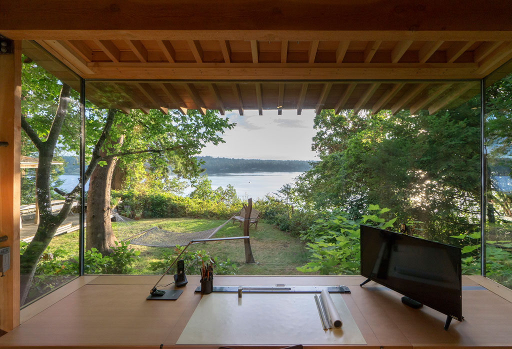 As a discrete structure, the Studio/Bunkhouse also allows the family to experience the climate and solitude of this deeply wooded site which sits at the top of a waterfront bluff, and is just 30 feet away from the main house. Photo credit: Art Grice