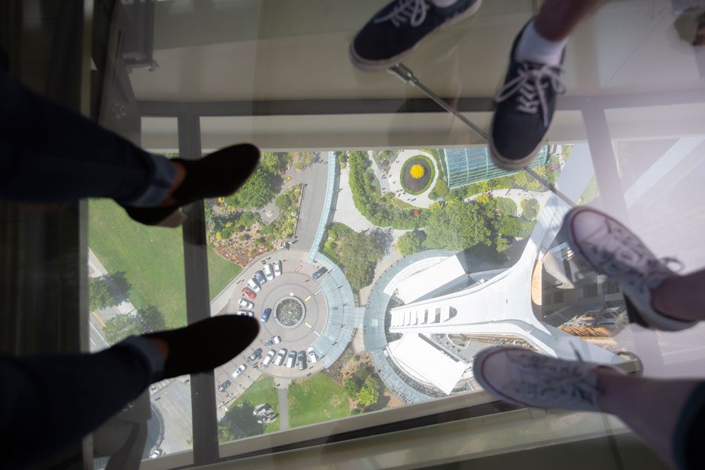 Guests step out onto Space Needle’s The Loupe, a revolving glass floor. Courtesy of John Lok and Space Needle LLC