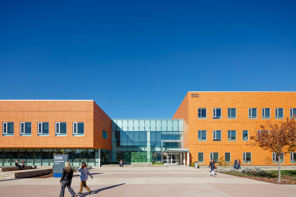 Main entrance: the simple terracotta façade echoes the campus’ material pallet; the main entry quietly welcomes visitors, patients, and medical personnel. Photo: © Tim Griffith and Kyle Jeffers