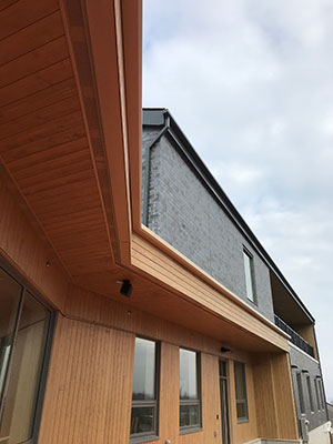A photo of Green Haven’s entrance canopy, which is clad in wood and brightly lit. Courtesy of Stantec